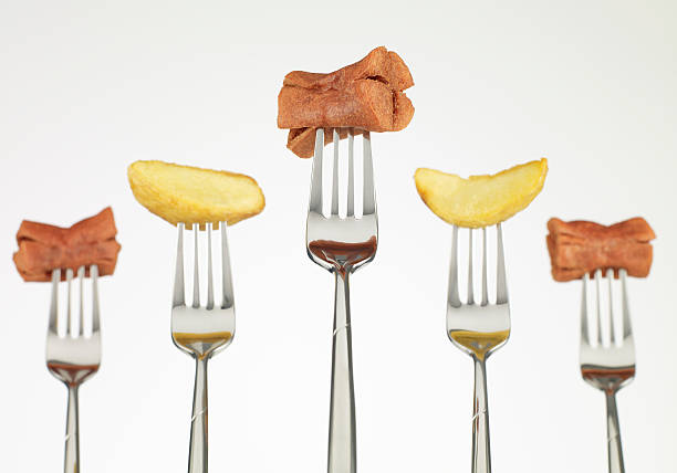 Sausages and potatos on fork, still-life.