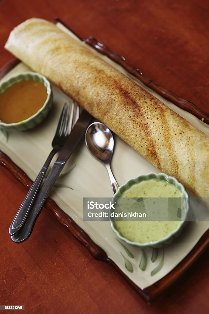 South Indian crepe Masala Dosa "The dosa (Dosay, Dose, Dosai, Dhosha, Thosai, Tosai,Chakuli) is a fermented crepe or pancake made from riceflour and black lentils. It is a typical dish in South Indian cuisine, eaten for breakfast or dinner, and is rich in carbohydrates and protein.Masala Dosa famous south Indian vegetarian snacks." Dosa Stock Photo