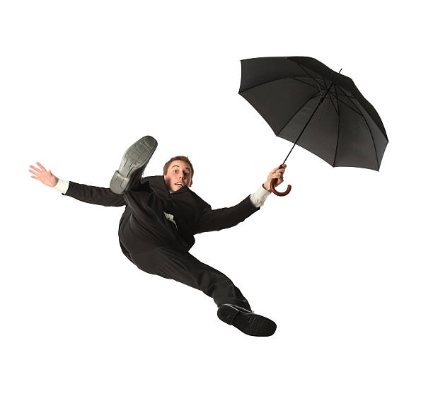 istock Isolated young businessman free falling while holding an umbrella 183321248