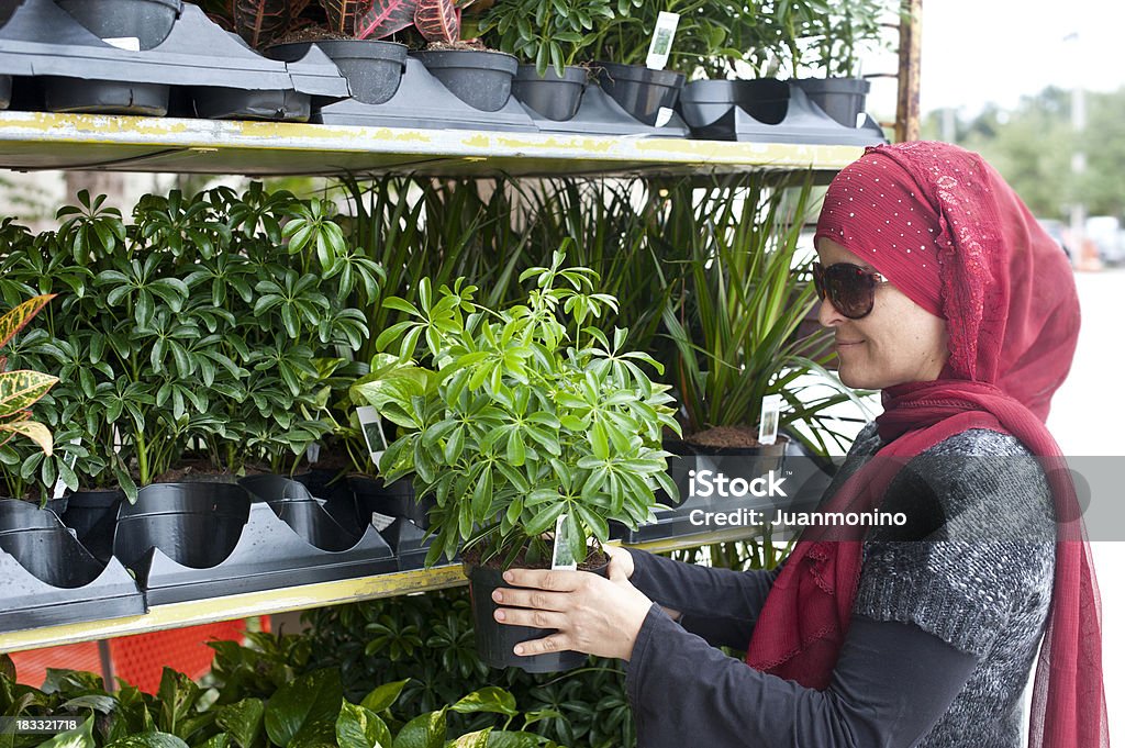 イスラム教徒の女性のショッピングの植物 - 1人のロイヤリティフリーストックフォト