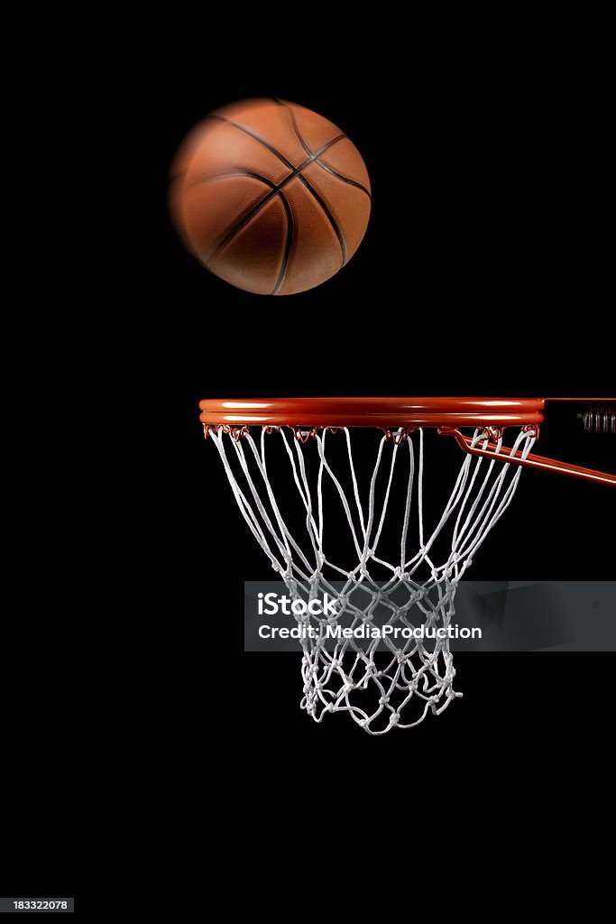 Basketball hoop net and ball side view Basketball just about to enter the hoop on black background Basketball Hoop Stock Photo