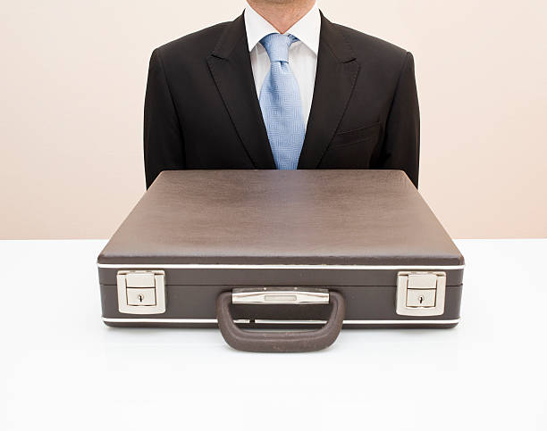 istock Closed Briefcase Against Sitting Businessman 183323088