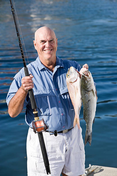 istock Senior fisherman with rod and fresh catch 183323719