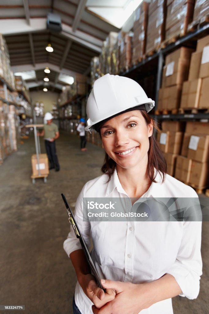 Lächelnd weibliche Vorgesetzten mit Arbeitnehmer im warehouse - Lizenzfrei Arbeitssicherheit Stock-Foto