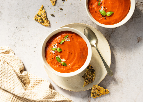 Tasty and creamy tomato soup made with fresh tomatoes and basil. Top view. copy space