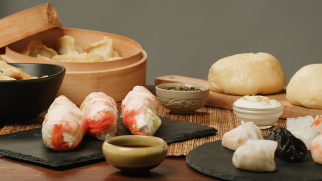 Dimsun, gyoza dumplings and spring rolls on table close-up. Food delivery. Homemade dishes