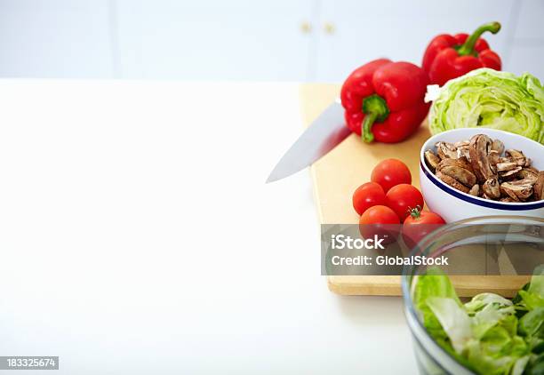 Variedad De Verduras En Tabla De Cortar Con Una Cuchilla Foto de stock y más banco de imágenes de Alimento