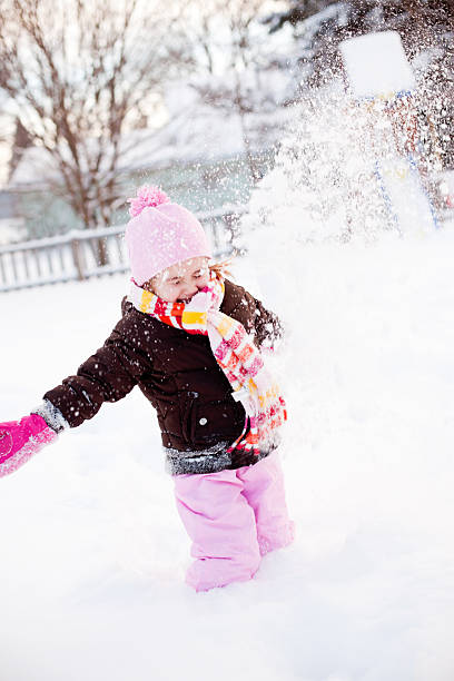 istock Little Girl Throwing Snow 183325828