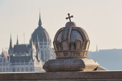 View of the the crown of Hungary on Margaret Bridge with the Hungarian Parliament and Citadella in the background