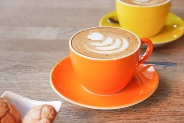 istock A cup of cappuccino in a orange color cup on table 1833273730