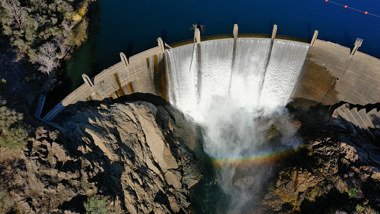 Drone photograph of Lake Clementine Dam overflowing with rainbow. is a reservoir on the North Fork American River Canyon (elevation 1,200 feet (370 m)) in Northern California.