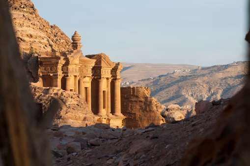 The 2000-year-old Monastery (also called al-Deir) in Petra, Jordan, viewed through the branches of a tree