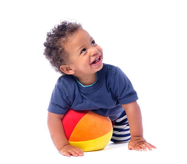 ребенок улыбается и смотреть вверх, играет с мячом - baby1 стоковые фото и изображения