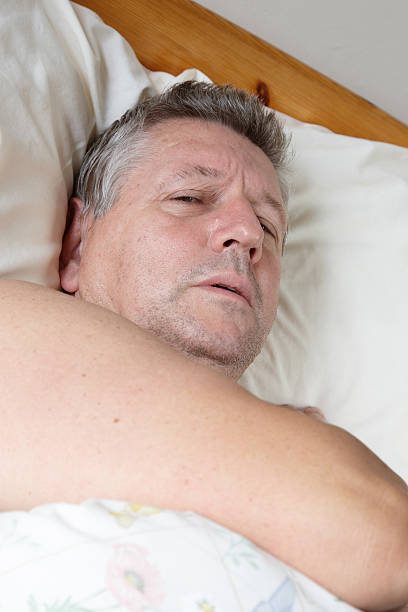 istock Mature man half asleep in bed 183328095
