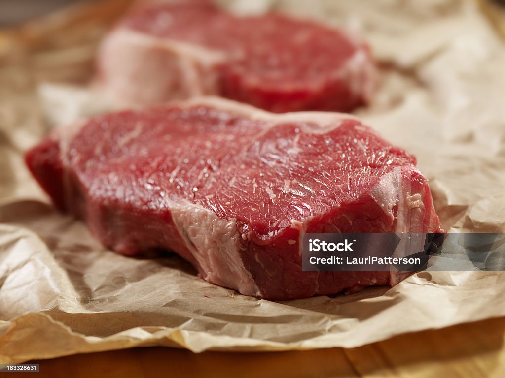 Materias primas bistecs en papel de carnicero - Foto de stock de Carnicería libre de derechos