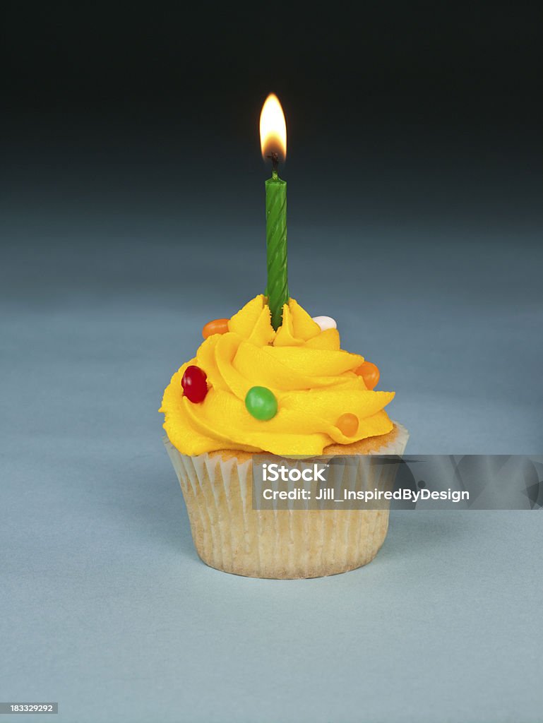 Cumpleaños Magdalenas con glaseado con amarillo frosting a fondo negro sobre azul - Foto de stock de Alcorza libre de derechos