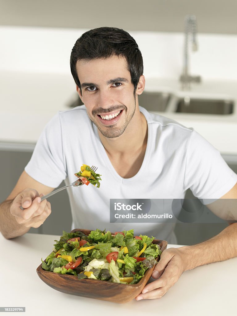 Man eating a big salad Man eating a big salad and looking at the camera Eating Stock Photo