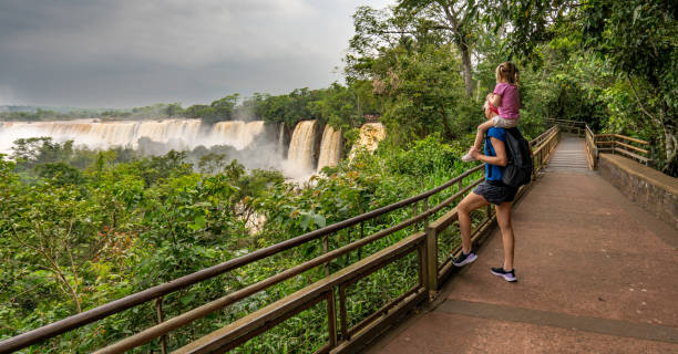 Mother and Daughter Enjoying the Breathtaking Mighty Iguazu Falls in Iguazu National Park on the Boarder of Argentina and Brazil, South America Mother and daughter enjoying the breathtaking mighty Iguazu Falls in Iguazu National Park on the Boarder of Argentina and Brazil, South America misiones province stock pictures, royalty-free photos & images