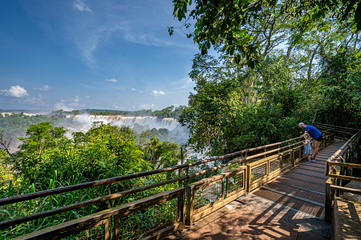Mother and daughter enjoying the breathtaking mighty Iguazu Falls in Iguazu National Park on the Boarder of Argentina and Brazil, South America