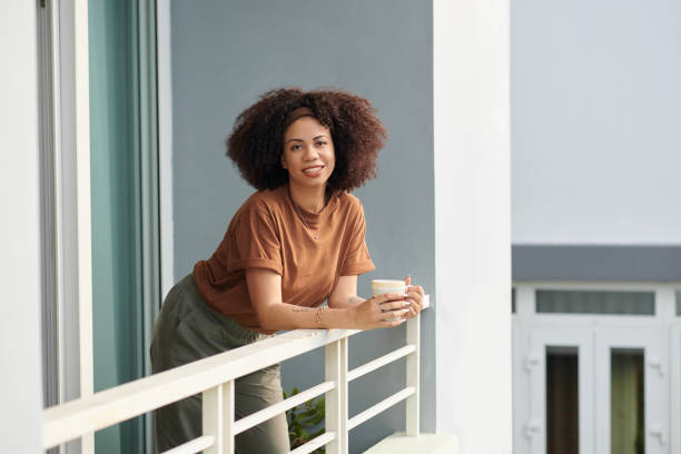 istock Woman Drinking Coffee on Balcony 1833301453