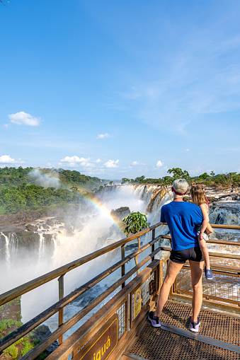 Mother and daughter enjoying the breathtaking mighty Iguazu Falls in Iguazu National Park on the Boarder of Argentina and Brazil, South America