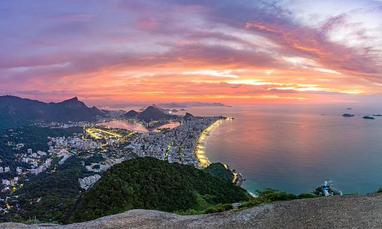 The awe inspiring view of the illuminated city and famous landmarks from Two Brothers Overlook at sunrise in Rio de Janeiro, Brazil.