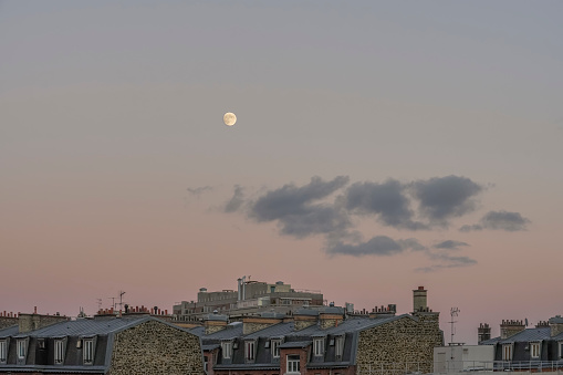 Paris, France - 11 25 2023: View of TDF microwave tower Romainville site, residential buildings and the moon in the sky