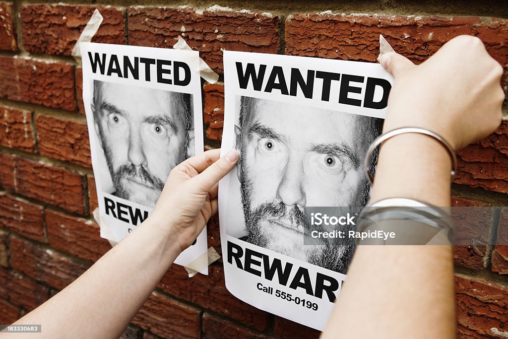 Mani di donna pin'Wanted'Colpo di boccale di muro di mattoni - Foto stock royalty-free di Muro