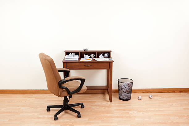 Desk littered with crumpled tax forms and a broken pencil.Please also see: