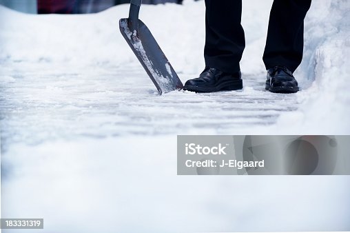 istock Welldressed man with snow shovel and copyspace 183331319