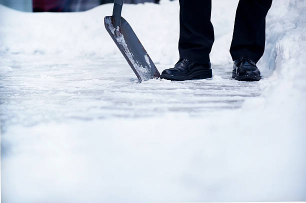 Welldressed man with snow shovel and copyspace stock photo