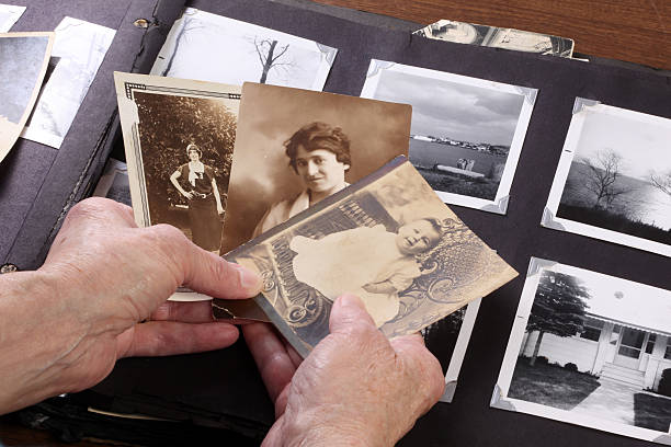 Memories Elderly hands holding vintage family photographs. origins photos stock pictures, royalty-free photos & images
