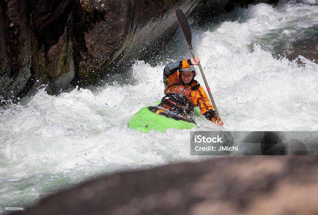 Donna pagaiando un White Water Kayak sul fiume Montana - Foto stock royalty-free di Rapida - Fiume