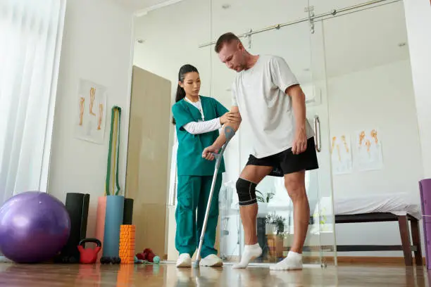 Photo of Nurse Supporting Patient Learning to Walk