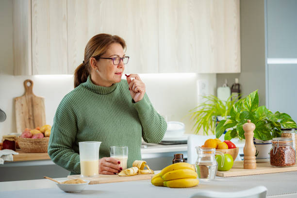istock Mature woman taking dietary supplement pill 1833327069
