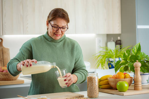 istock Woman in kitchen pouring protein drink into a glass 1833327953