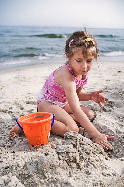 istock Little girl playing with wet sand 183333427