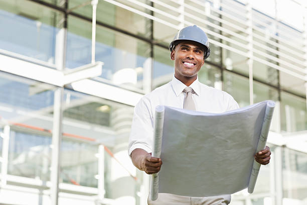 istock Businessman in a Hardhat and Looking at Blueprints 183334331