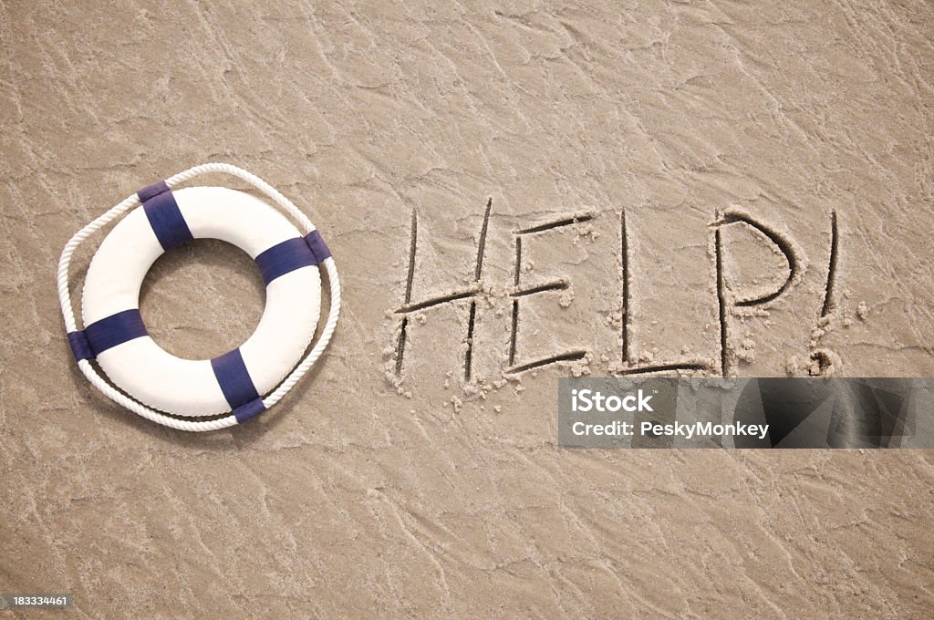 Help Message Written in Sand with Lifesaver Help! message written in textured sand features a lifesaver SOS - Single Word Stock Photo