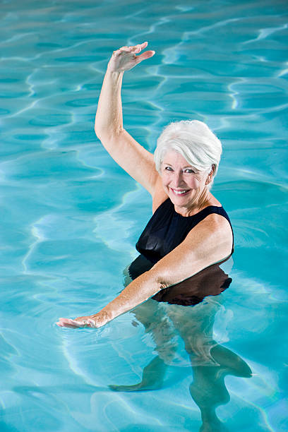 istock Active senior woman exercising in swimming pool 183334542