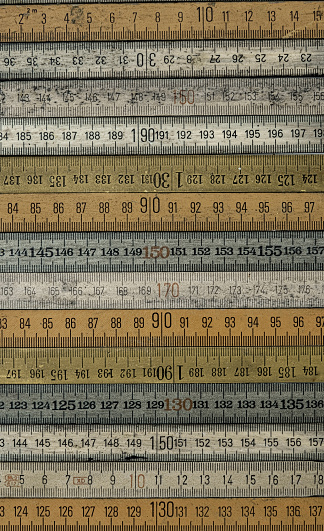 A variety of vintage wooden folding rulers arranged, full frame
