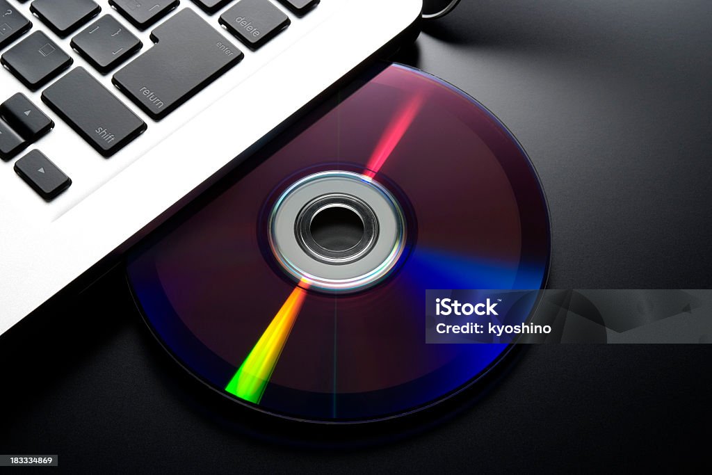 挿入、CD /DVD をノートパソコンに黒色の背景 - CD-ROMのロイヤリティフリーストックフォト