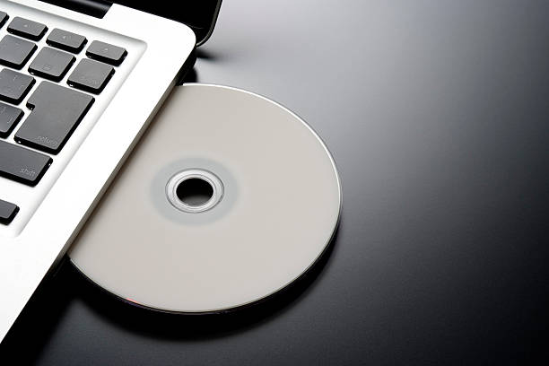 hineinstecken einem cd-rohling in einen laptop - dvd fotos stock-fotos und bilder