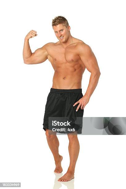 Muscular Man Flexión Biceps Foto de stock y más banco de imágenes de Flexionar los músculos - Flexionar los músculos, Hombres, Musculoso