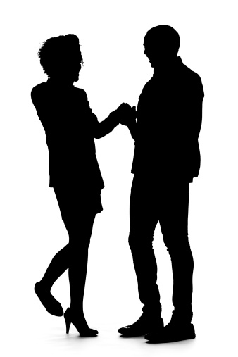 A silhouette of a young adult African American couple, having a dance or greeting one another; isolated on a white studio background.