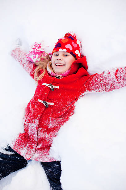 istock Young Girl Laying in Snow Making Angel 183335099