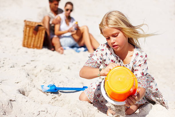 istock Girl building sandcastle 183335444