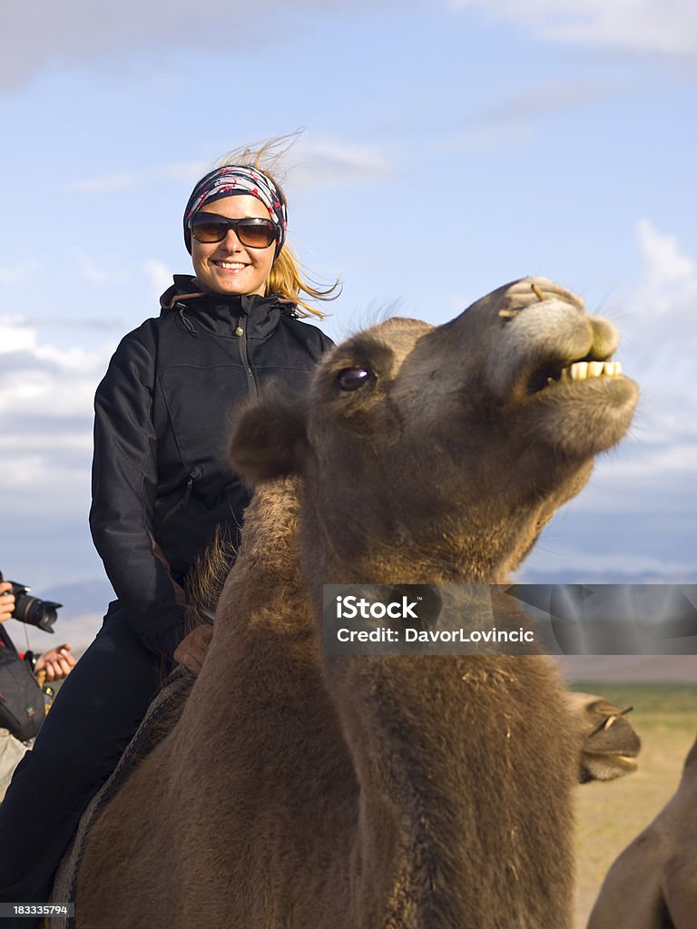 Camel riding "Young and beautiful  lady as Mongol  on camelback riding at the edge of Dunes in Gobi desert in summer, Hongoran Els, south Mongolia." Gobi Desert Stock Photo