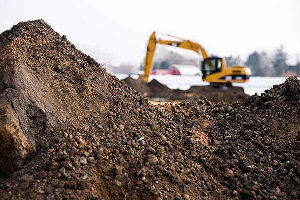 Photo of machinery and dirt piles during winter construction stock photo