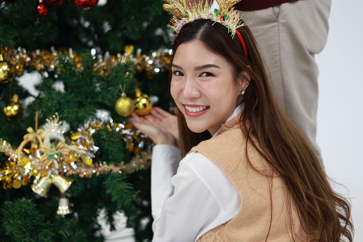 Portrait cute woman decorating Christmas tree